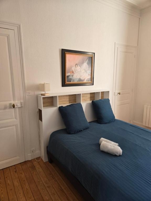 une chambre avec un lit bleu avec des oreillers bleus dans l'établissement Le Balcon d'Anatole 3étoiles, au Mans