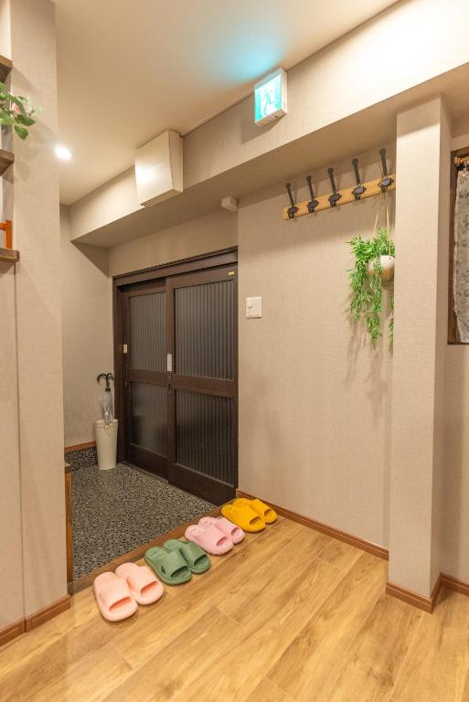 大阪Guest House Kubo Homes Tengachaya 1的地板上有一排鞋的房间