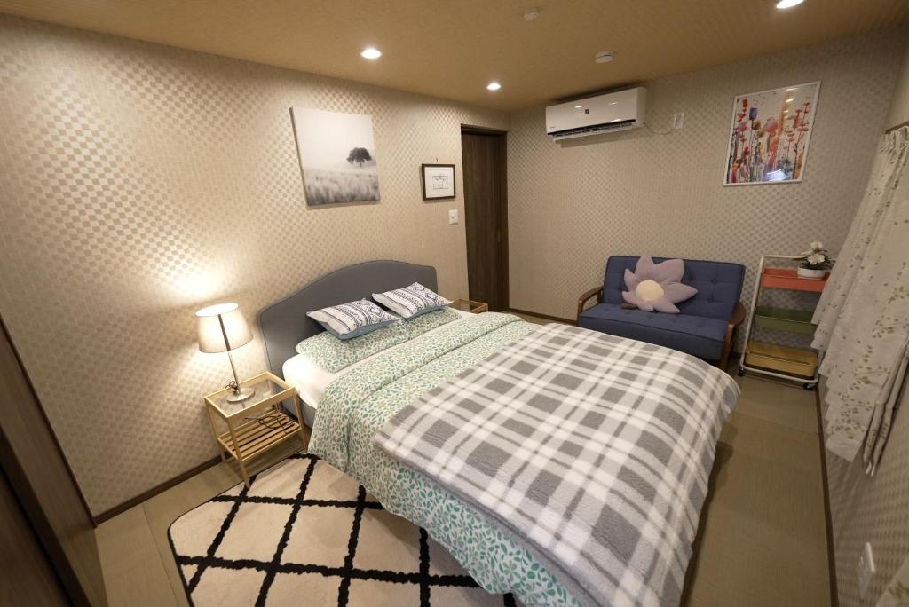 大阪Guest House Kubo Homes Tengachaya 1的一间小卧室,配有一张床和一张蓝色椅子