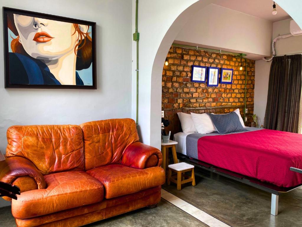 a bedroom with a bed and a couch and a painting at VL Hotel Boutique by Rotamundos in Guadalajara
