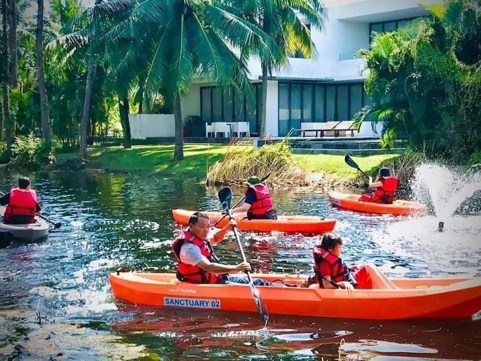 - un groupe de personnes en canoë-kayak sur l'eau dans l'établissement Villa Luxury 5 Phòng ngủ Hồ bơi riêng - Resort Sanctuary Hồ Tràm, à Xuyên Mộc