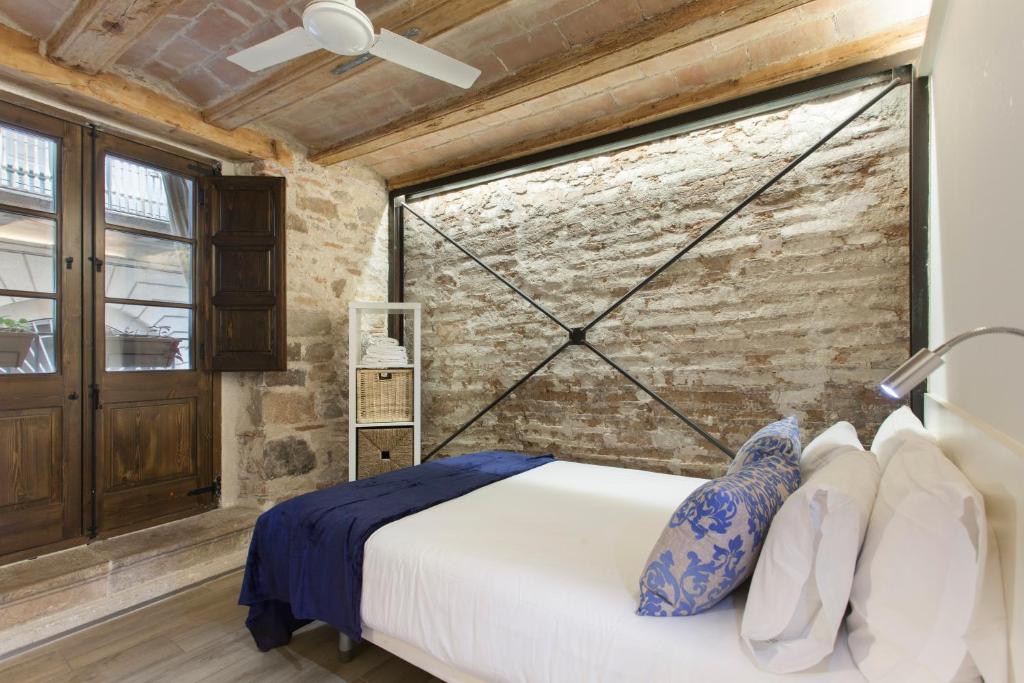 a bedroom with a bed and a brick wall at Barcelona Classic Palau Apartments in Barcelona