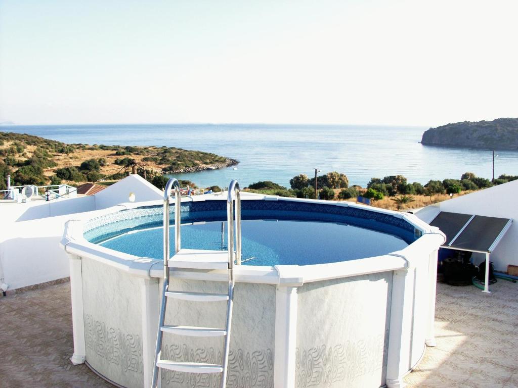 a hot tub with a ladder next to the ocean at Vrokastro Apartments in Istro