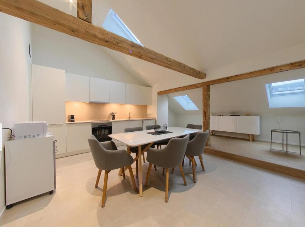 a kitchen and dining room with a table and chairs at Bright and Airy 1-Bedroom Flats in Neuchâtel City Center! RDM2 in Neuchâtel