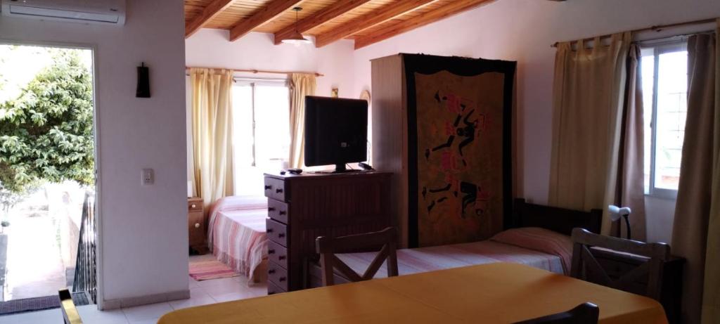 Un dormitorio con una cama, un televisor y una mesa. en Departamento Con Vistas a La Montaña, en Villa Carlos Paz