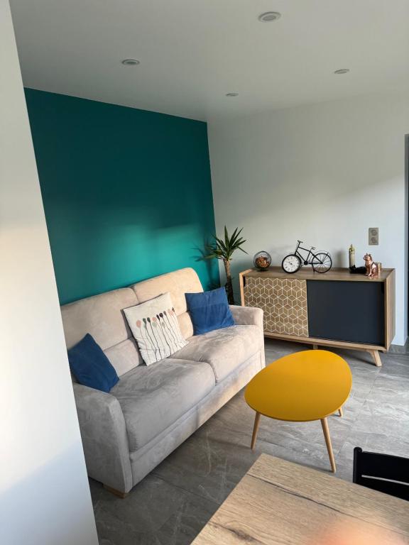 - un salon avec un canapé et un mur vert dans l'établissement VILLA RIZEE à 14min de Paris & proche DisneyLand Resort, à Chelles