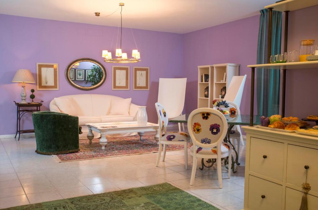 sala de estar con paredes de color púrpura, mesa y sillas en B&B Maison Biagetti, en Santarcangelo di Romagna