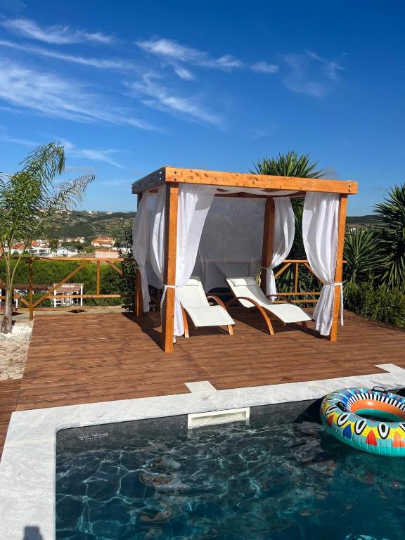 a gazebo and chairs next to a swimming pool at KABACEIRA VILLAGE in Atalaia