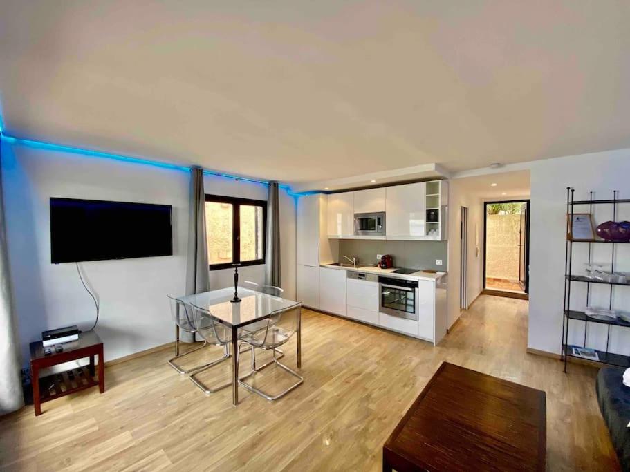 a large living room with a table and a television at MarinesAppartement, La terrasse Tropézienne in Saint-Tropez