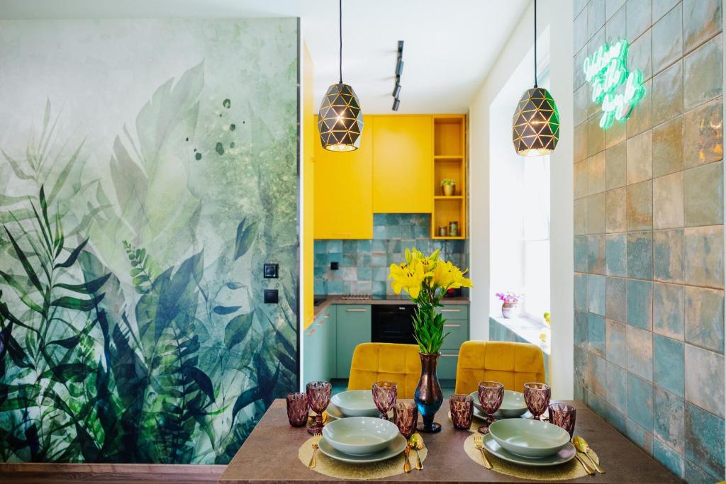 a dining room with a table and yellow cabinets at Jungle Apartment chill&bed Zator in Zator