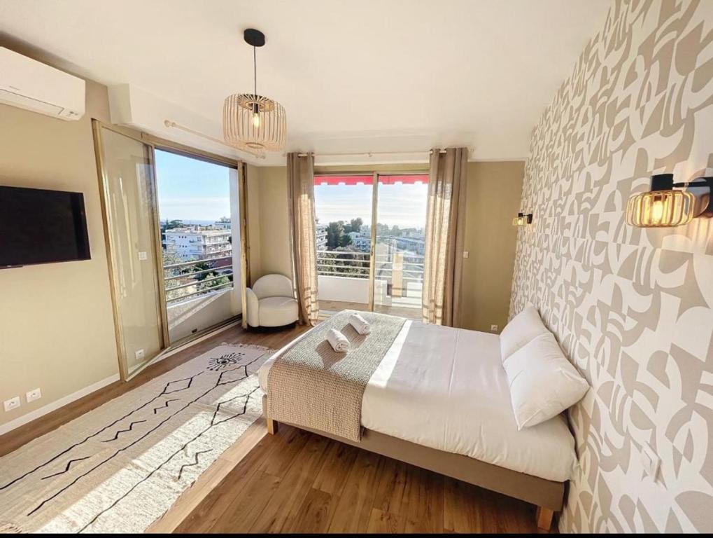 une chambre avec un grand lit et une grande fenêtre dans l'établissement Spacieux appartement à Nice 4 chambres, à Nice