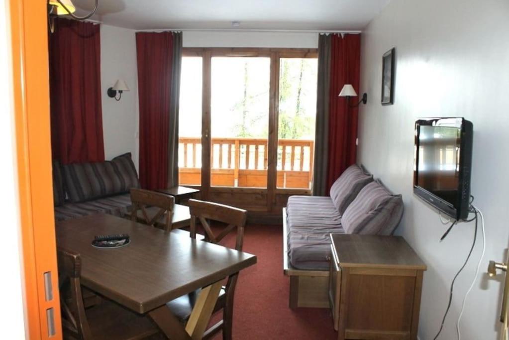 a living room with a couch and a table at appartement 5 places à VARS in Vars