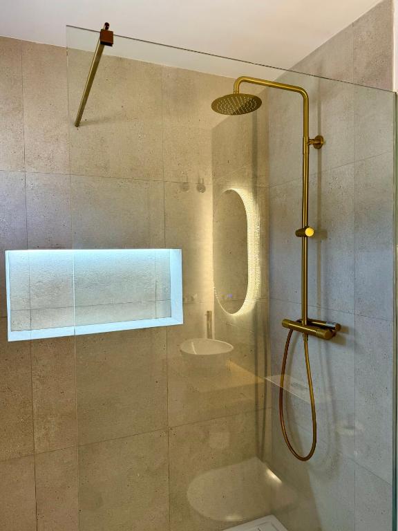 ducha con puerta de cristal junto a un aseo en SunnyPalms - Beachfront Penthouse with stunning sea view, en Estepona