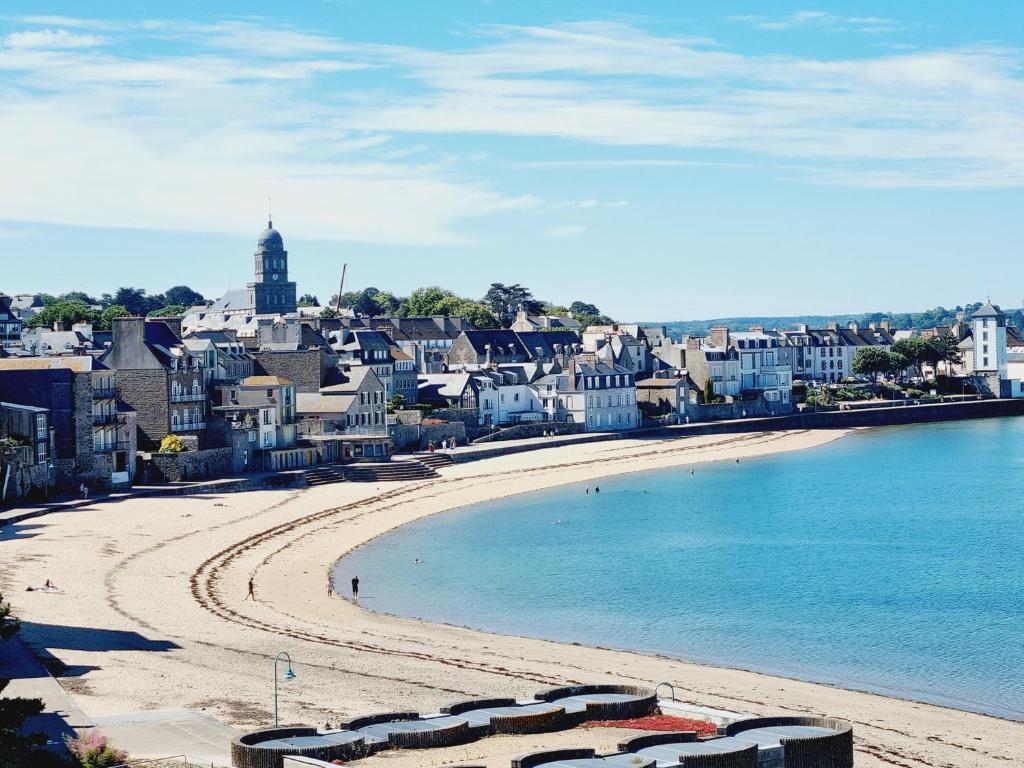 - une vue sur une plage avec une ville en arrière-plan dans l'établissement Belle vue sur les sablons, à Saint-Malo