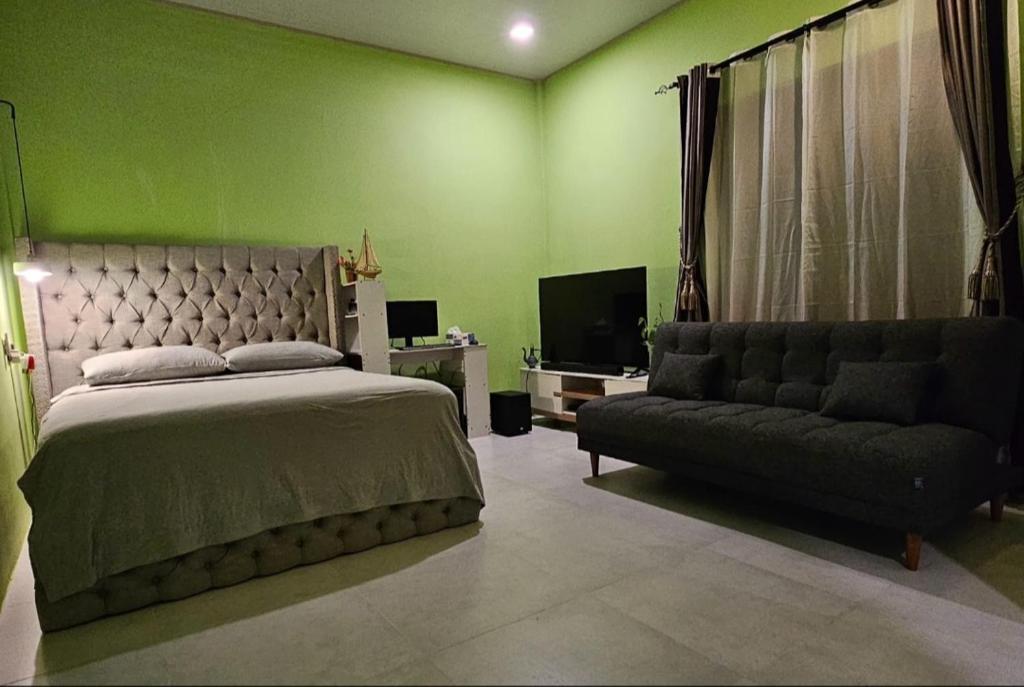 a bedroom with a bed and a couch at Iruka Guesthouse in Faresmathoda