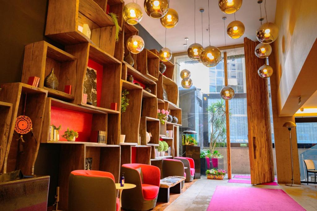 a waiting room with red chairs and wooden shelves at Las Suites Campos Eliseos in Mexico City