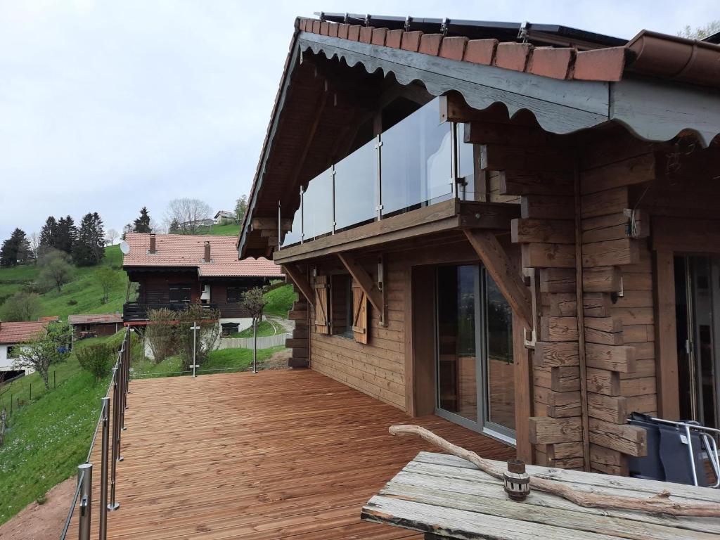 ein Haus mit Holzterrasse und Balkon in der Unterkunft Chalet Les Bouvreuils La Bresse Haute Vosges in La Bresse
