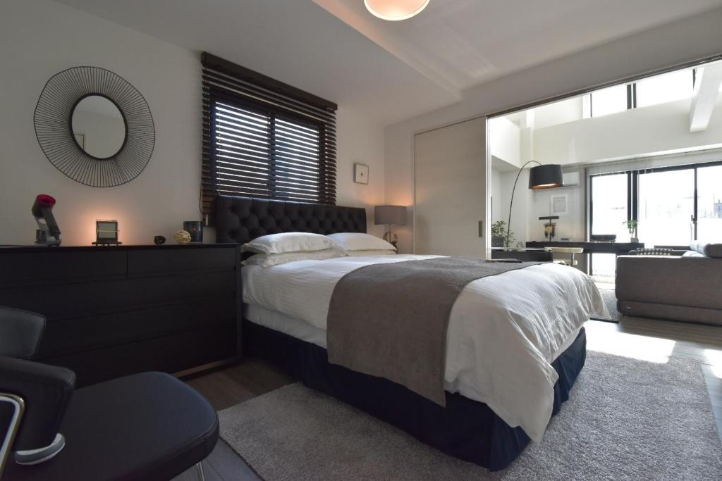 a bedroom with a bed and a mirror and a chair at LANG - Vacation STAY 22203v in Tokyo