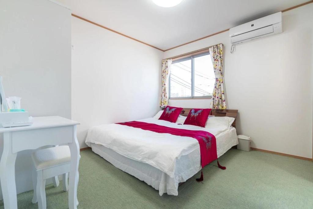 een slaapkamer met een bed, een bureau en een raam bij Travel Palace Miyuki - Vacation STAY 16820 in Kawaguchi