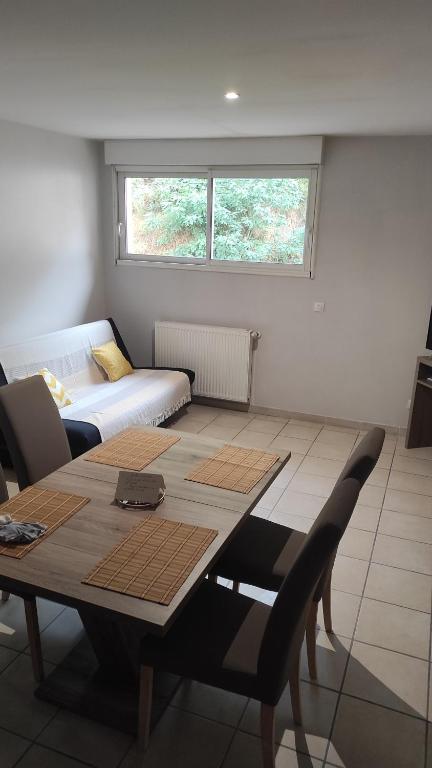 un salon avec une table et un canapé dans l'établissement Appartement 4 couchages - Centre ville St Donat sur l'Herbasse, à Saint-Donat-sur-lʼHerbasse
