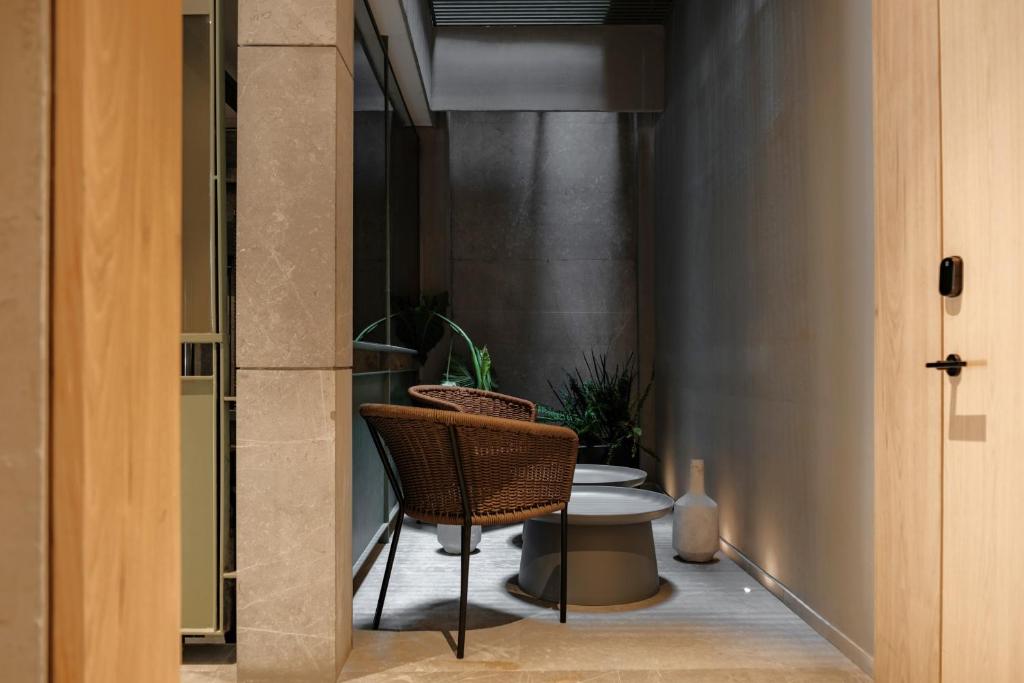 a bathroom with a rattan chair and a toilet at Casa Cibeles by Lumina in Mexico City