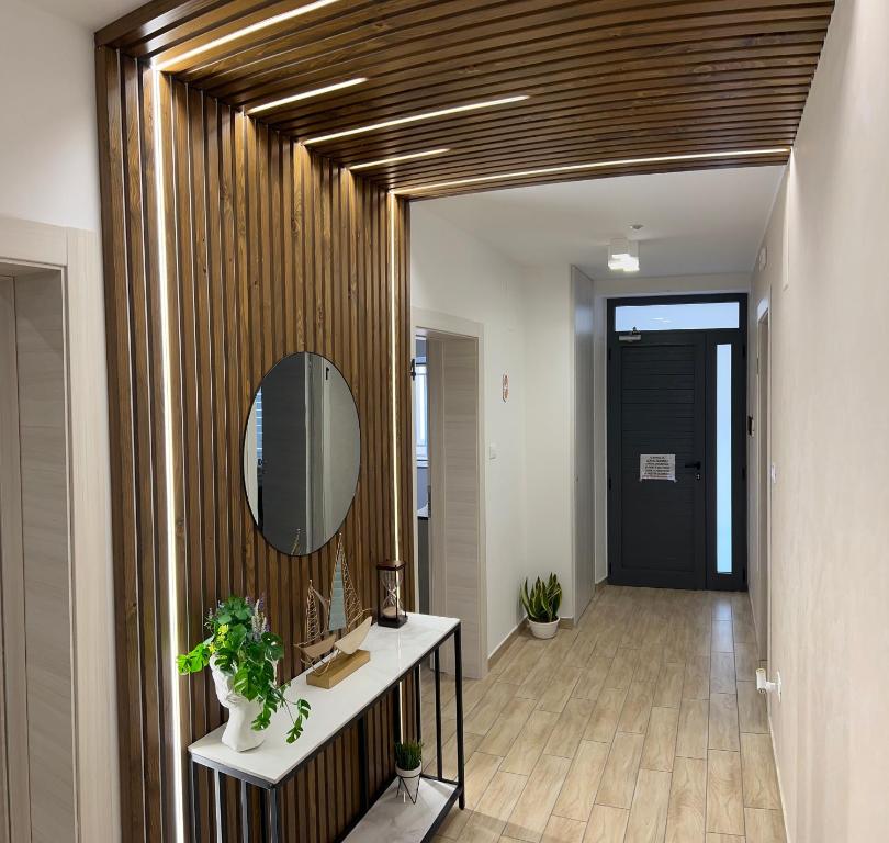 a hallway with a mirror and a table with plants at Aramarina B&B in Schiavonea