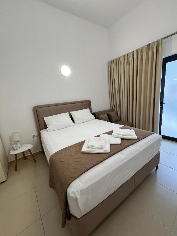 a bedroom with a bed with two towels on it at Sun's Suites in Asprovalta
