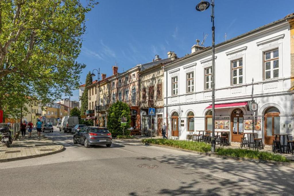 a street with buildings and a car driving down the street at Apartmani Leo centar in Crikvenica
