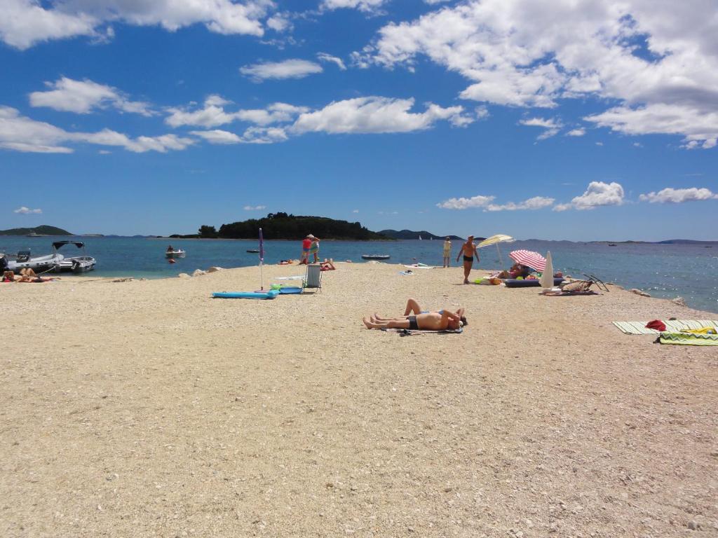 a group of people laying on a beach at Kamp Mara in Pakoštane