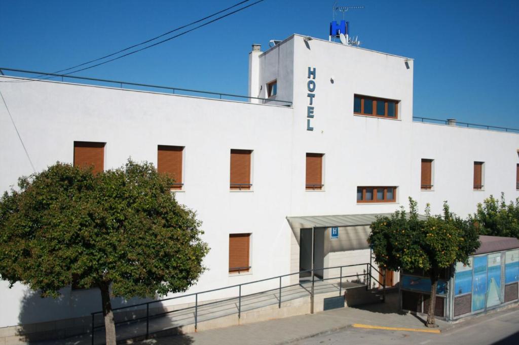 um edifício branco com uma árvore em frente em Hotel Albanta em La Lantejuela