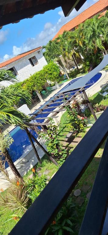a view of a patio with umbrellas and palm trees at Falésias de Carapibus - Casa de temporada 06 - Jacumã in Conde