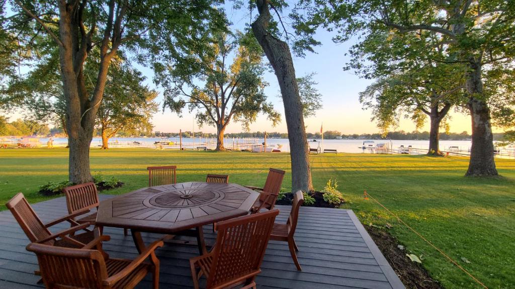 una mesa de madera y sillas en una terraza con vistas al agua en Lake Of The Woods Sunset Shore, en Bremen