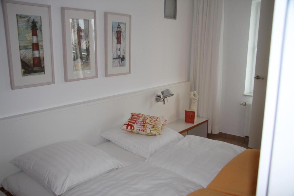 a bedroom with a bed and two pictures on the wall at Feriendomizil am Kurplatz in Norderney