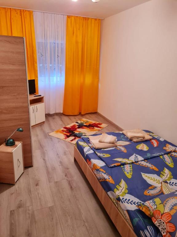 a bedroom with a bed with a colorful comforter at Apartament Costescu 2 in Băile Herculane