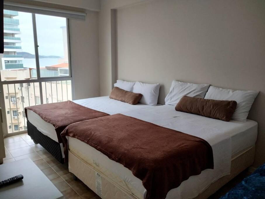 瓜拉派瑞Apartamento Guarapari Castanheiras的一间带大床和大窗户的卧室