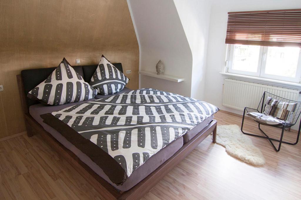 a bedroom with a bed with black and white pillows at Ferienwohnung Waldblick in Bad König