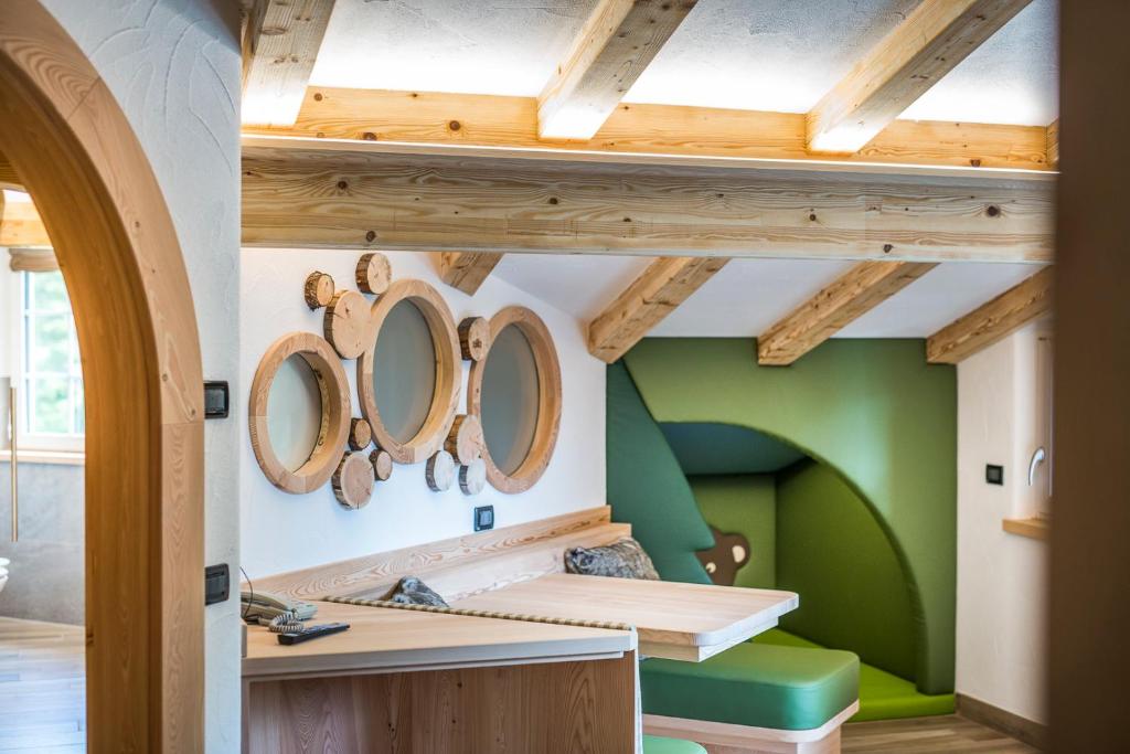 a room with green walls and wooden ceilings at Chalet Pineta relax location in Canazei