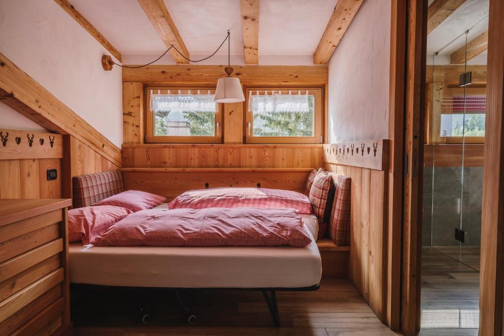 a bedroom with a bed in the corner of a room at Chalet Pineta relax location in Canazei