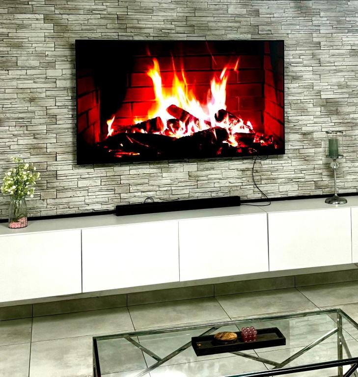 d'une cheminée avec une télévision sur un mur en briques. dans l'établissement Appartement t3 70 m2, à Vénissieux