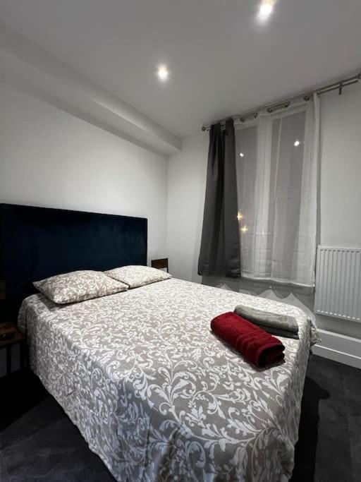 une chambre avec un lit avec un oreiller rouge dessus dans l'établissement Appartement Neuf Côté La Défense, à Courbevoie