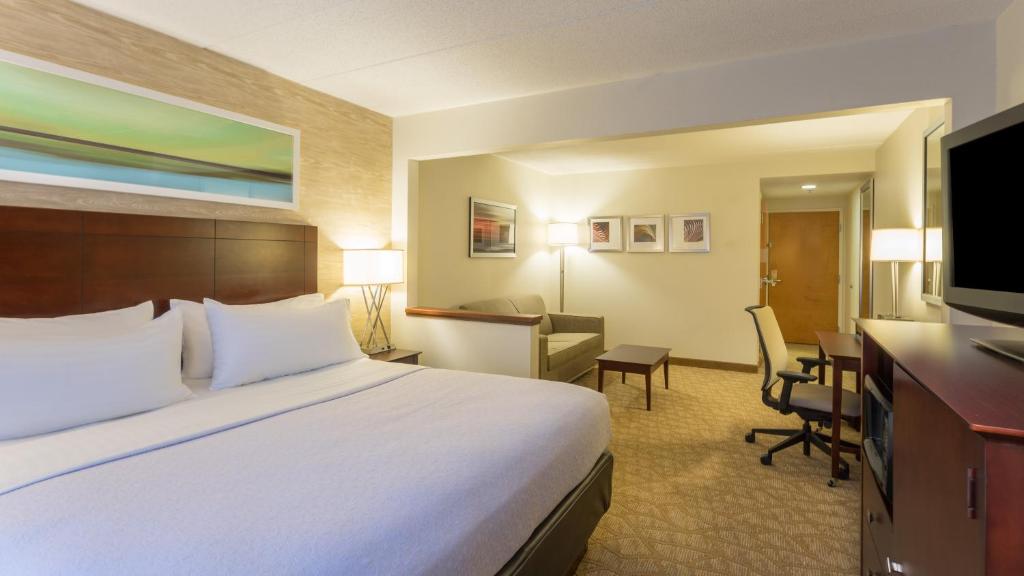 a hotel room with a large bed and a desk at Holiday Inn Baltimore BWI Airport by IHG in Linthicum Heights