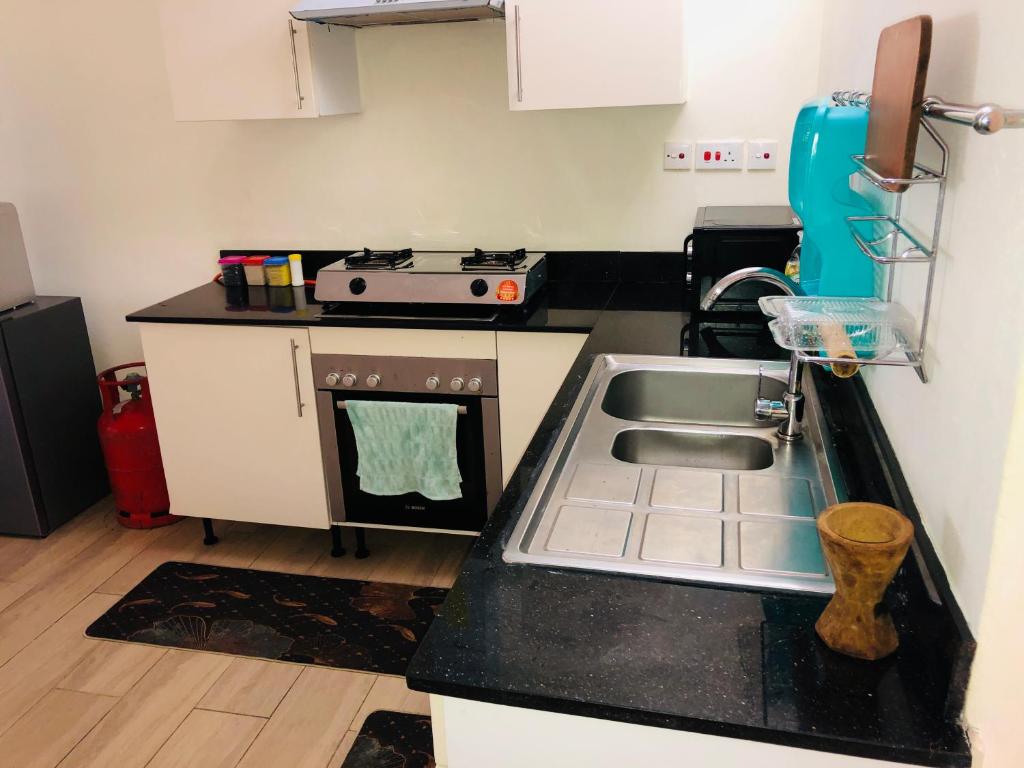a kitchen with a sink and a stove at Harmony Homes Beachfront in Diani Beach
