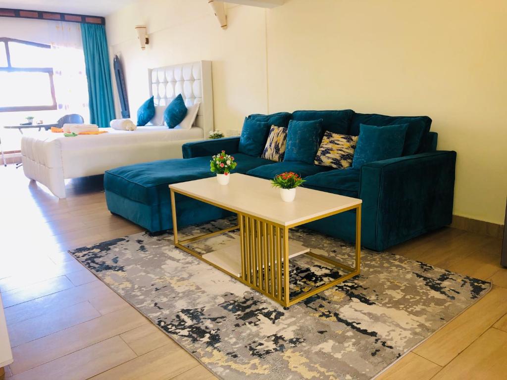 a living room with a blue couch and a table at Harmony Homes Beachfront in Diani Beach