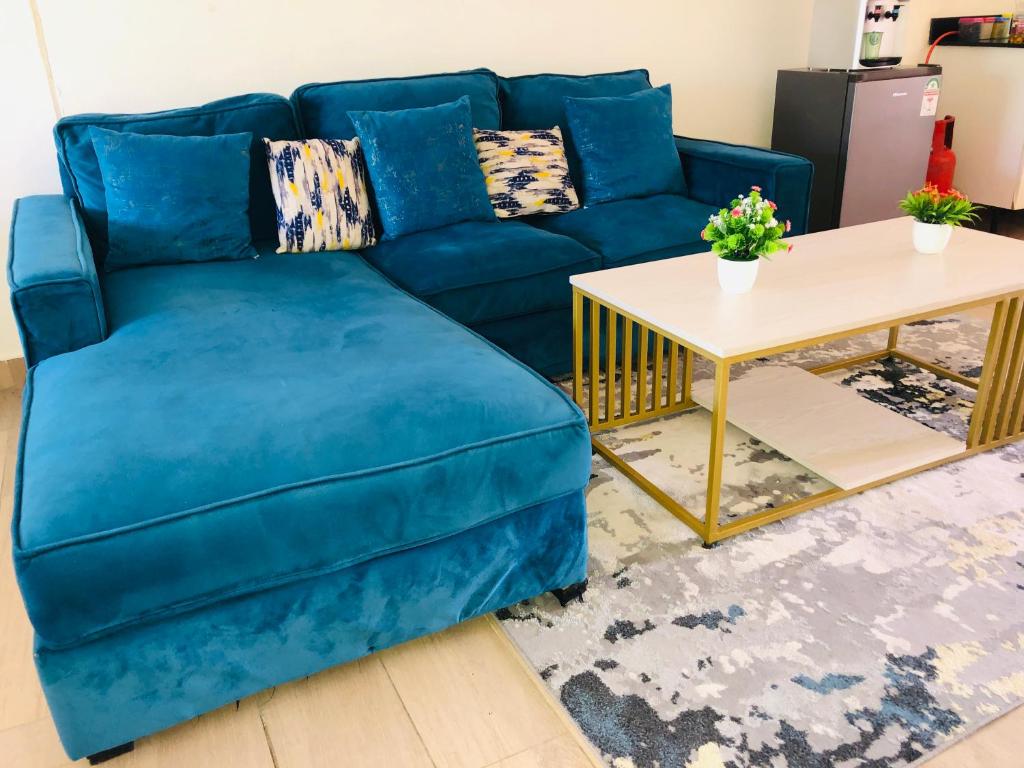 a blue couch in a living room with a table at Harmony Homes Beachfront in Diani Beach