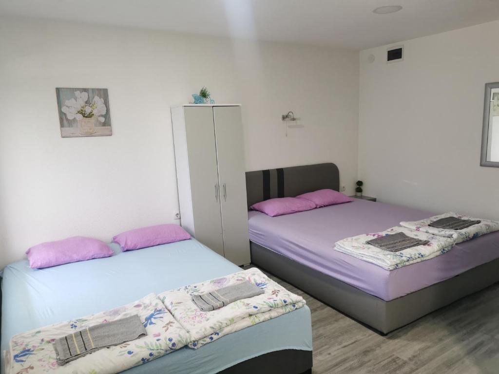 two beds sitting next to each other in a room at Holit in Ohrid