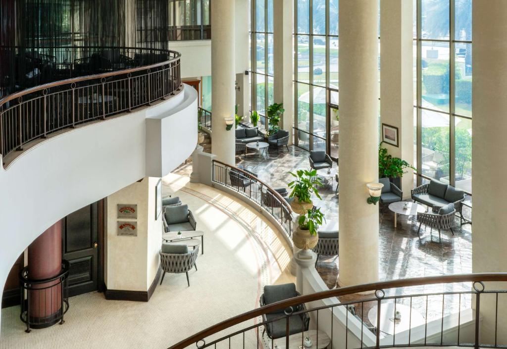 a spiral staircase in a building with chairs and tables at Radisson Blu Hotel & Resort, Abu Dhabi Corniche in Abu Dhabi