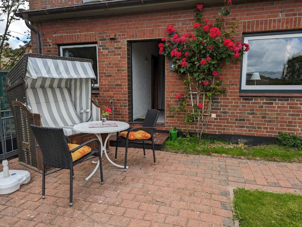 a patio with a table and chairs and a building at Haus Dorfschmiede, Whg Seestern in Alkersum