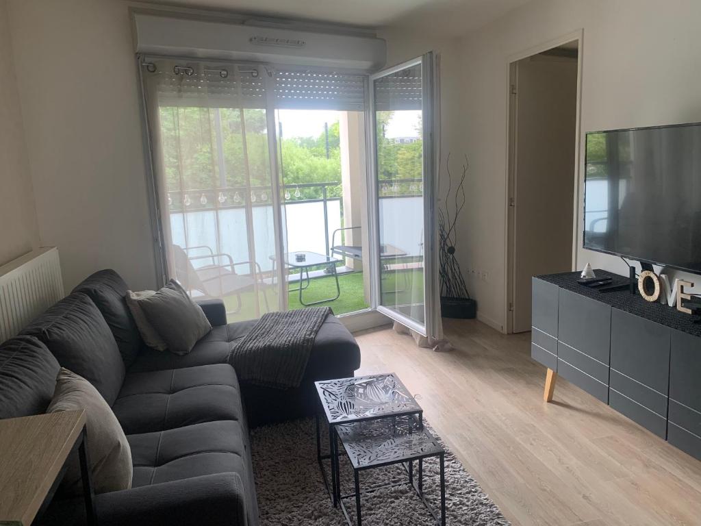 un salon avec un canapé et une télévision à écran plat dans l'établissement Appartement cosy à Alforville avec Parking, à Alfortville