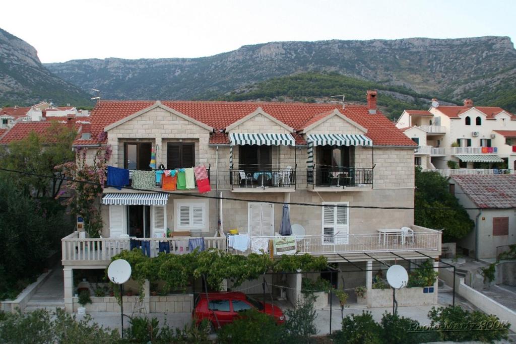 a house with clothes drying on a balcony at Apartments with parking space Bol, Brac - 12980 in Bol