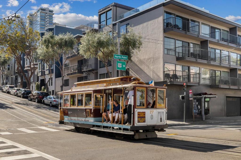 Un carrito con gente viajando en él en una calle de la ciudad. en The Suites at Fisherman's Wharf, en San Francisco